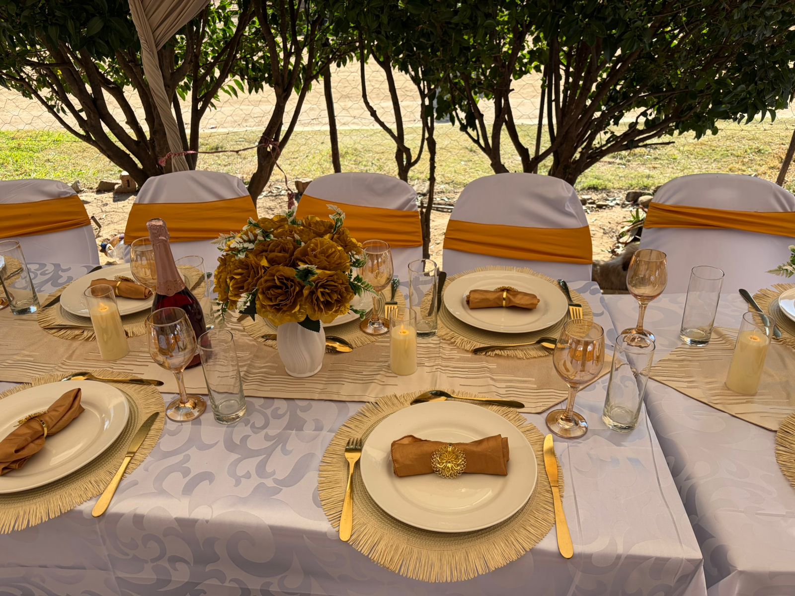 Sisterly Touch restaurant setup with gold napkins, floral centrepiece, and gold cutlery.